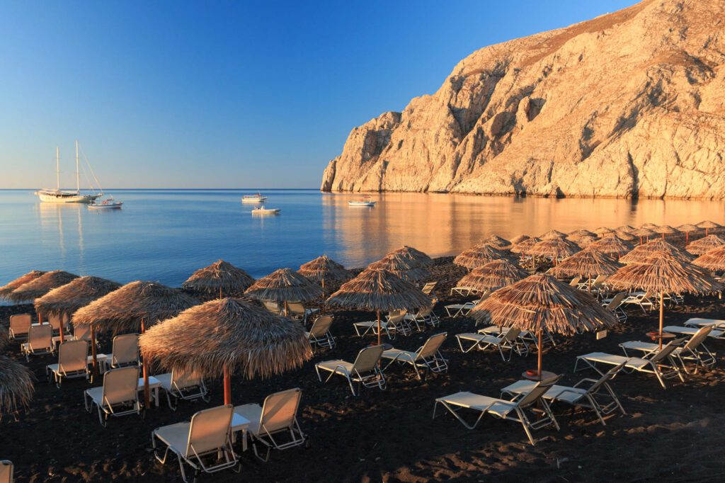 How do you get around Santorini's black sand beaches?